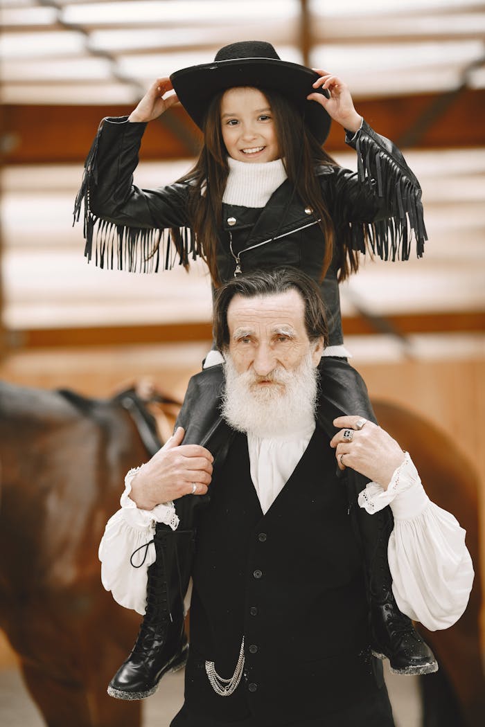 A joyful moment with a grandfather and granddaughter dressed in western outfits enjoying time together.